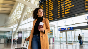 Traveler walking through an airport with a passport, symbolizing a job seeker visa for working abroad in 2026
